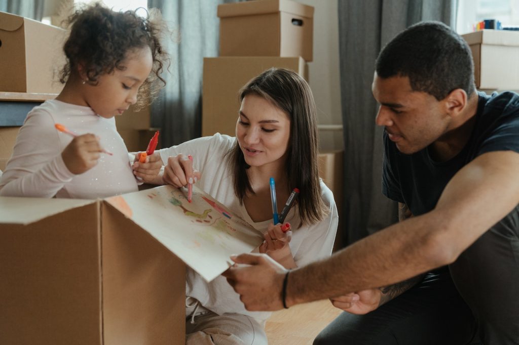 a family drawing on moving boxes together
